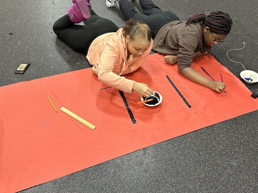 Photo of Jasmine Bland and Emanuela Djikounou working together on a poster