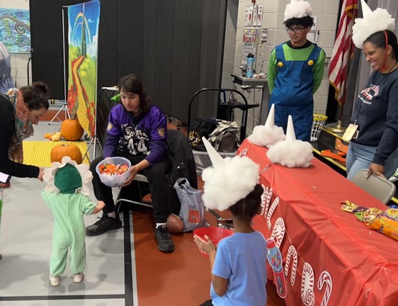 TJ Student J.B. offers candy to an adorable baby at the Rock Creek Recreation Center’s Trick or Treat. 